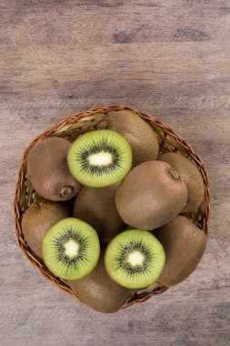 Ahşap bir yüzey üzerinde bir sepet içinde biraz kivi