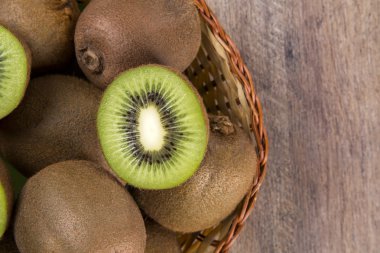 Ahşap bir yüzey üzerinde bir sepet içinde biraz kivi