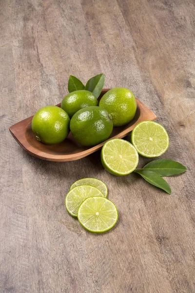 Fresh citrus lime with mint close up on wooden background