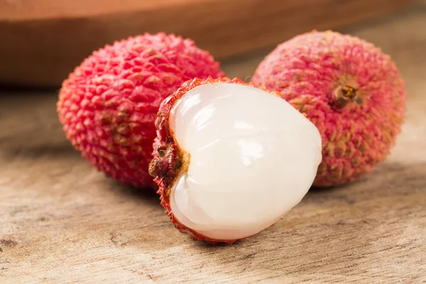 Verse lychees op houten oppervlak. — Stockfoto