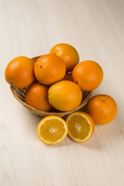 Primer plano de algunas naranjas en una canasta sobre un fondo blanco . — Foto de Stock