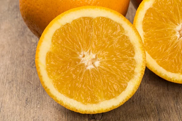 Nahaufnahme einiger Orangen in einem Korb über einer Holzoberfläche — Stockfoto