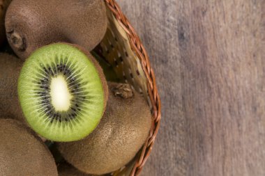 Ahşap bir yüzey üzerinde bir sepet içinde biraz kivi