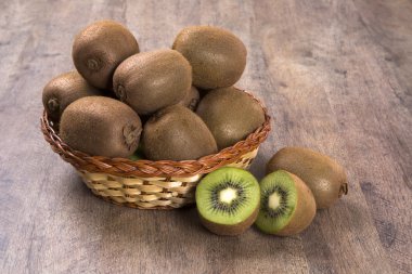 Ahşap bir yüzey üzerinde bir sepet içinde biraz kivi