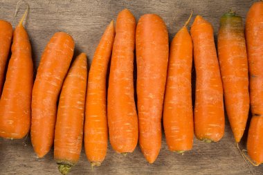 ahşap masa üzerinde yeşil yaprakları ile taze havuç