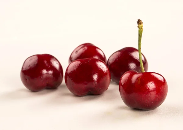 A wooden pot full of cherries over a wooden surface — Stock Photo, Image