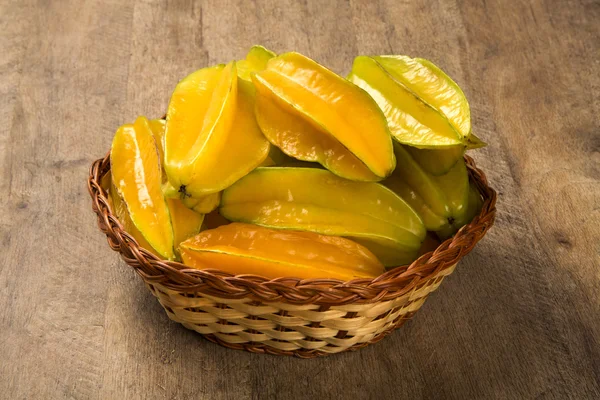 Sommige caramboles in een mand over een houten oppervlak — Stockfoto