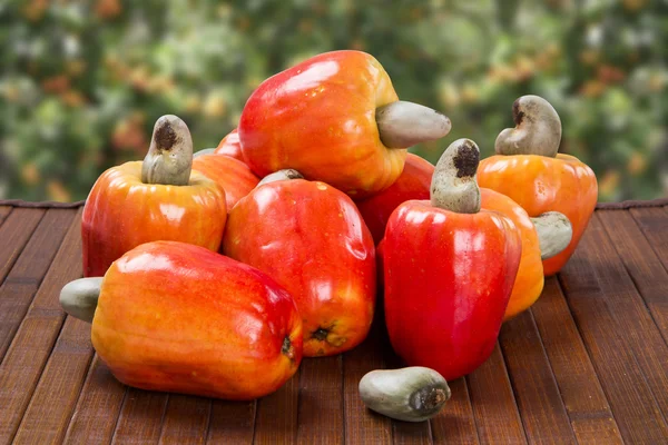 Ein Holzteller mit ein paar Cashewnüssen über einer Holzoberfläche. — Stockfoto