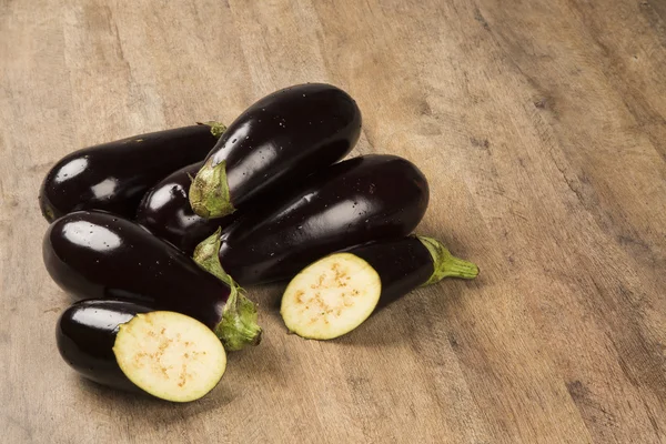 Sommige aubergines over een houten oppervlak — Stockfoto