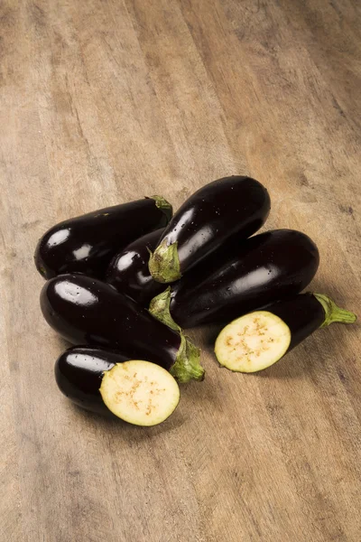 Sommige aubergines over een houten oppervlak — Stockfoto