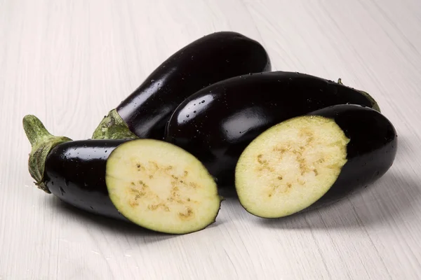 Sommige aubergines over een houten oppervlak — Stockfoto