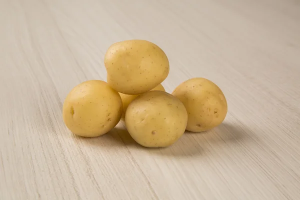 Ein paar Kartoffeln auf einer hölzernen Fläche — Stockfoto