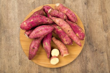 surowego słodkie ziemniaki na drewniane tł