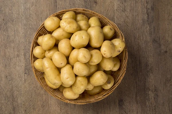 Alcune patate su una superficie di legno — Foto Stock