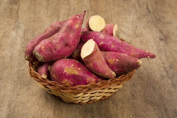 Rohe Süßkartoffeln auf hölzernem Hintergrund — Stockfoto