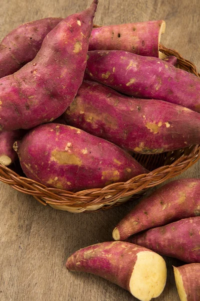 Rohe Süßkartoffeln auf hölzernem Hintergrund — Stockfoto