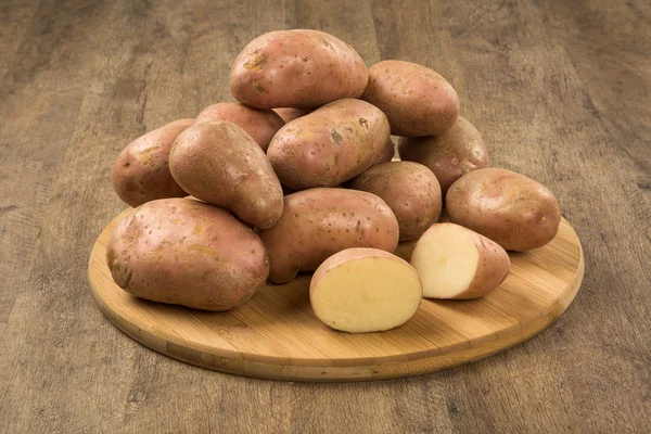 Fresh potatoes on rustic wooden background — Stock Photo, Image