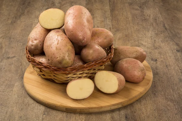 Свежий картофель на деревенском деревянном фоне — стоковое фото