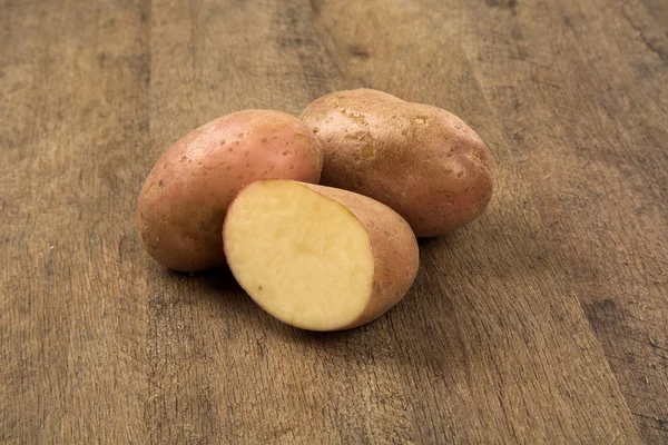 Fresh potatoes on rustic wooden background — Stock Photo, Image