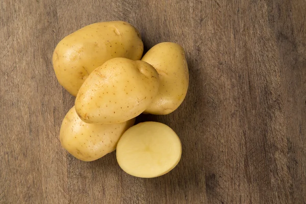 Kilka ziemniaków na powierzchni drewnianych — Zdjęcie stockowe