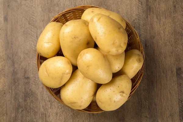 Some potatoes over a wooden surface — Stock Photo, Image