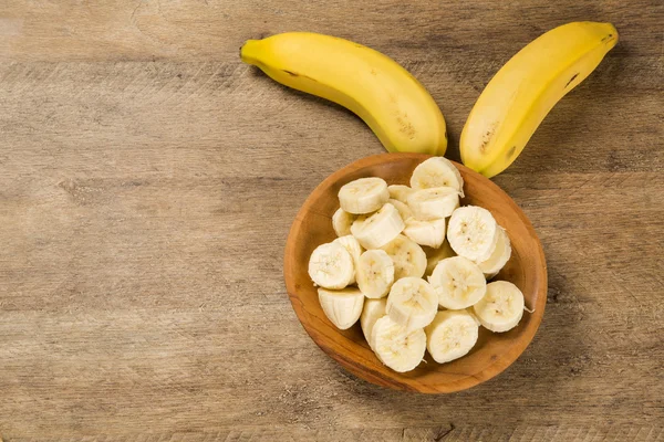Una panchina di banane e una banana affettata — Foto Stock