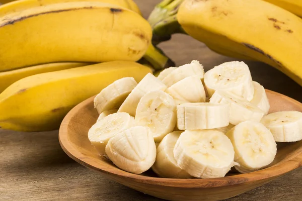 A banch of bananas and a sliced banana