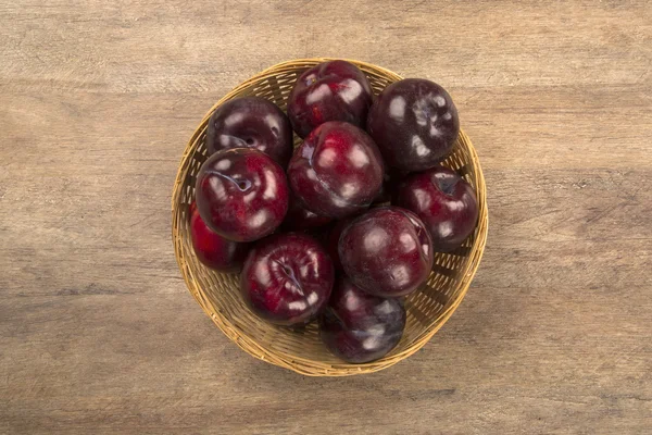 Fresh bright plums in the bowl on board — Stock Photo, Image