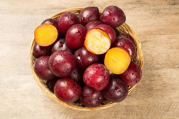 Fresh bright plums in the bowl on board — Stock Photo, Image