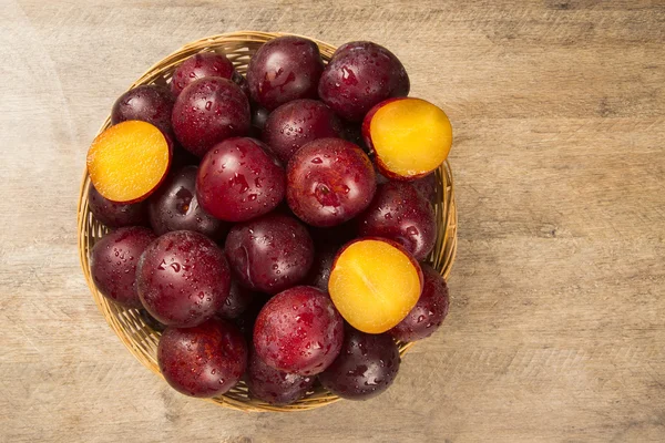 Fresh bright plums in the bowl on board — Stock Photo, Image