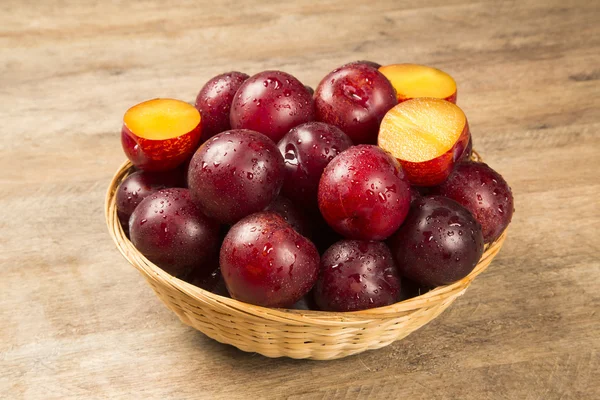 Fresh bright plums in the bowl on board — Stock Photo, Image