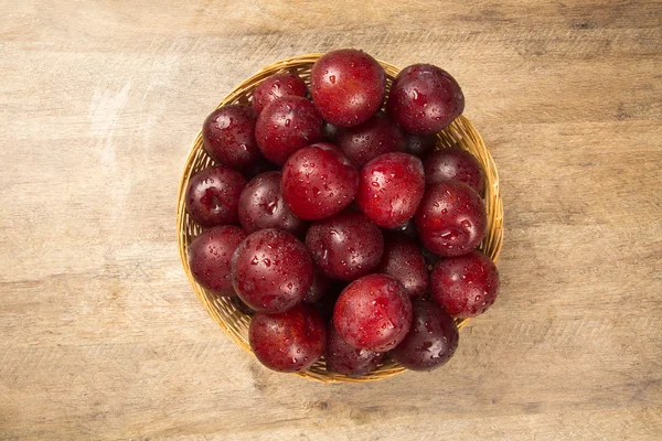 Fresh bright plums in the bowl on board — Stock Photo, Image