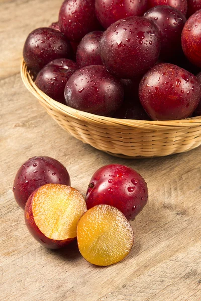 Frische helle Pflaumen in der Schüssel an Bord — Stockfoto