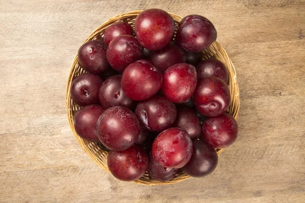 Fresh bright plums in the bowl on board — Stock Photo, Image