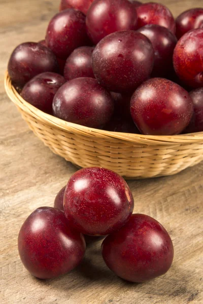 Fresh bright plums in the bowl on board — Stock Photo, Image