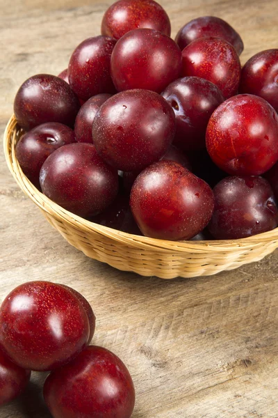 Fresh bright plums in the bowl on board — Stock Photo, Image