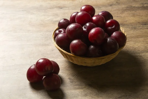 Fresh bright plums in the bowl on board — Stock Photo, Image
