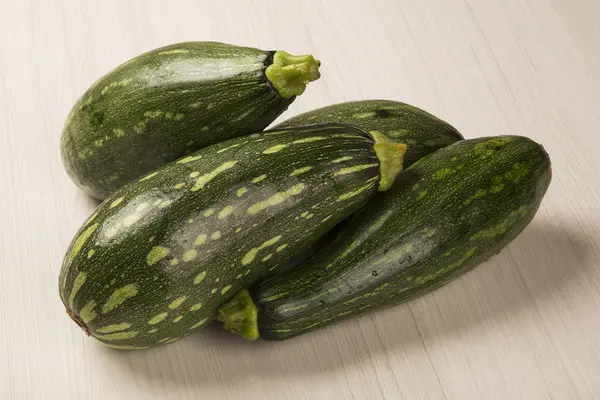 Vissa zucchinis över en vit trä yta — Stockfoto
