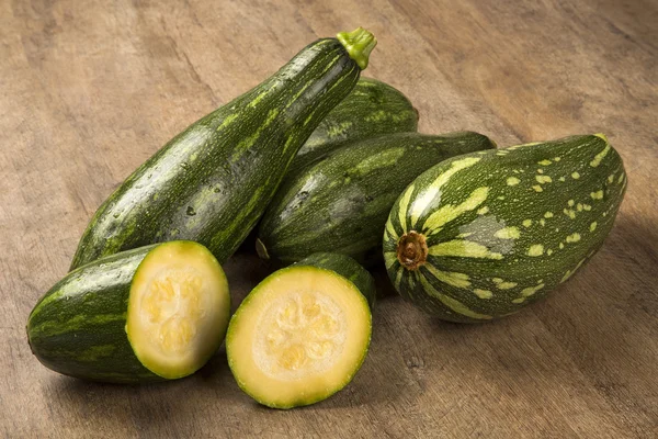 Some zucchinis over a white wooden surface. — Stock Photo, Image