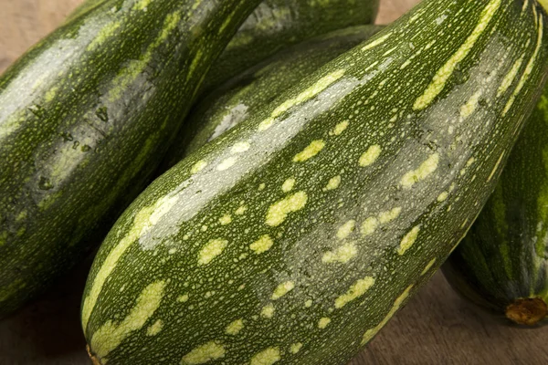 Algunos zucchinis sobre una superficie de madera blanca — Foto de Stock