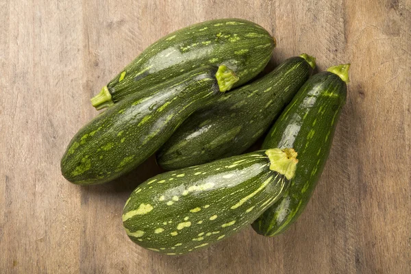 Algunos zucchinis sobre una superficie de madera blanca — Foto de Stock