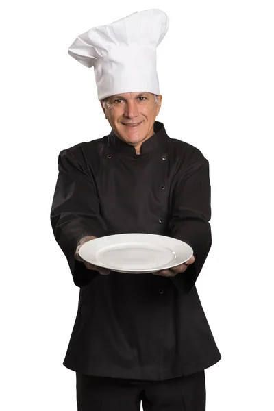 Chef mature confiant en uniforme noir tenant une assiette vide . — Photo