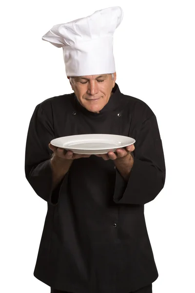 Fiducioso cuoco maturo in uniforme nera con piatto vuoto . — Foto Stock