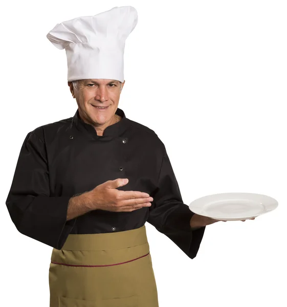 Säker mogna kock i svart uniform håller Tom tallrik. — Stockfoto