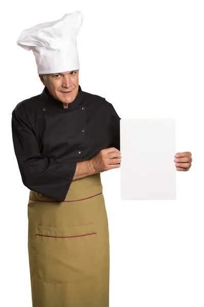 Volwassen man chef-kok in uniforme duimschroef opwaarts en lege visitekaartje weergegeven:. — Stockfoto