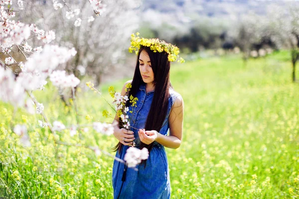 Niña con flores en el callejón de flores de primavera — Foto de Stock