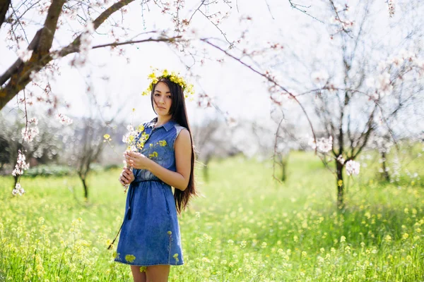 Niña con flores en el callejón de flores de primavera — Foto de Stock