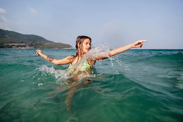 Sexy bikini girl swim sea waves splash — Stock Photo, Image