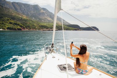 Kız akıllı telefon fotoğraf cruise ile Yatçılık