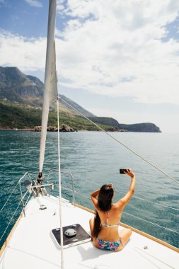 Kız akıllı telefon fotoğraf cruise ile Yatçılık